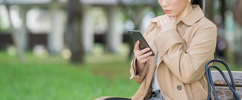 スマホで鍵開け業者を探す女性